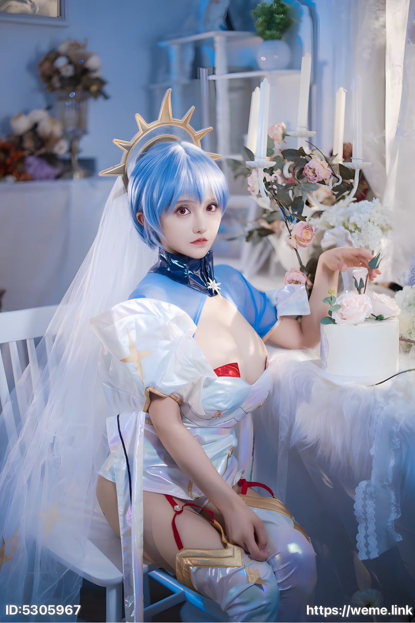古阿扎戴金色星形头冠穿蓝白亮面服装坐在蛋糕烛台与花束之间 古阿扎戴金色星形头冠穿蓝白亮面服装坐在蛋糕烛台与花束之间