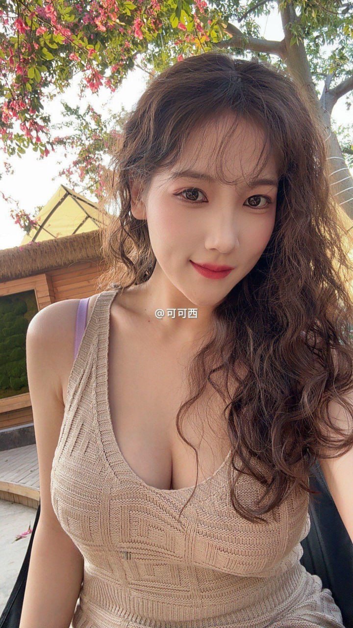 可可西yyy穿米色无袖针织裙站在开花树木与木墙旁 可可西yyy穿米色无袖针织裙站在开花树木与木墙旁