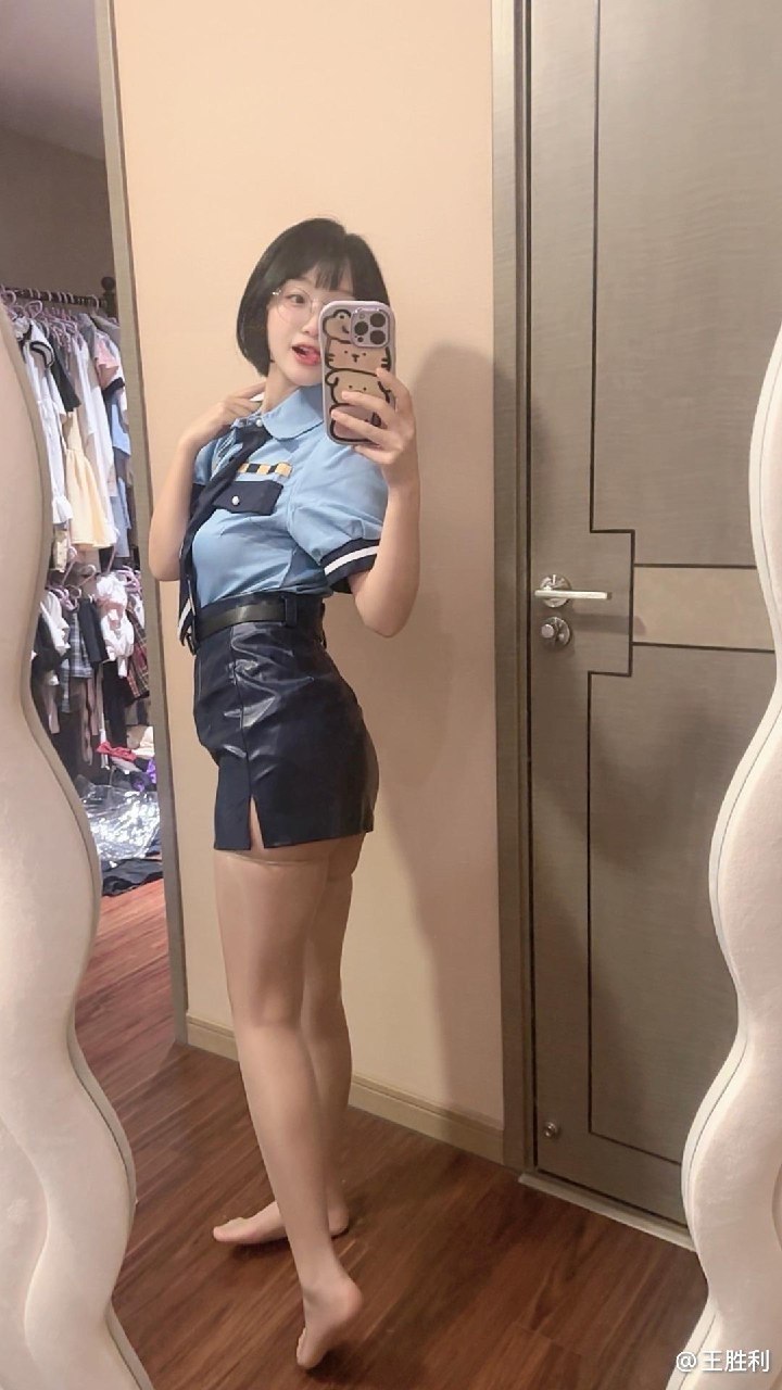 王胜利浅蓝衬衣与深色短裙镜面侧站姿，旁有开放衣柜