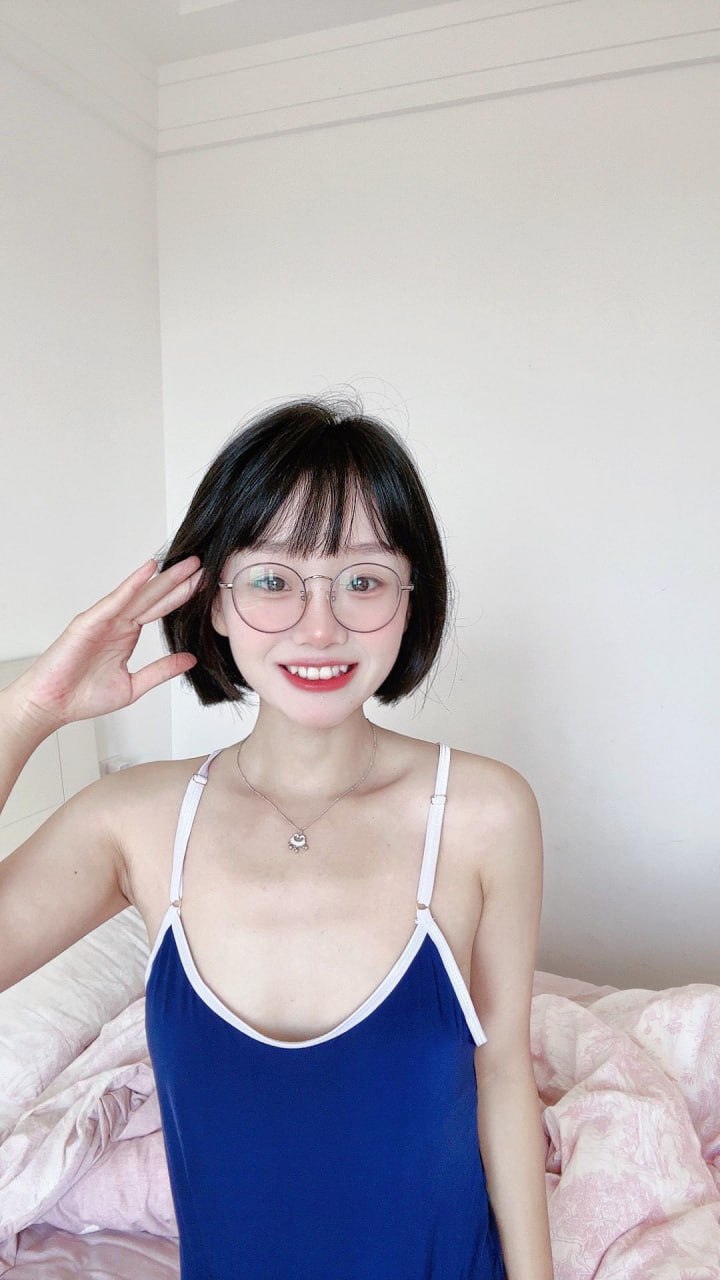 王胜利蓝色白边衣装近景，短发与圆框眼镜清晰可见
