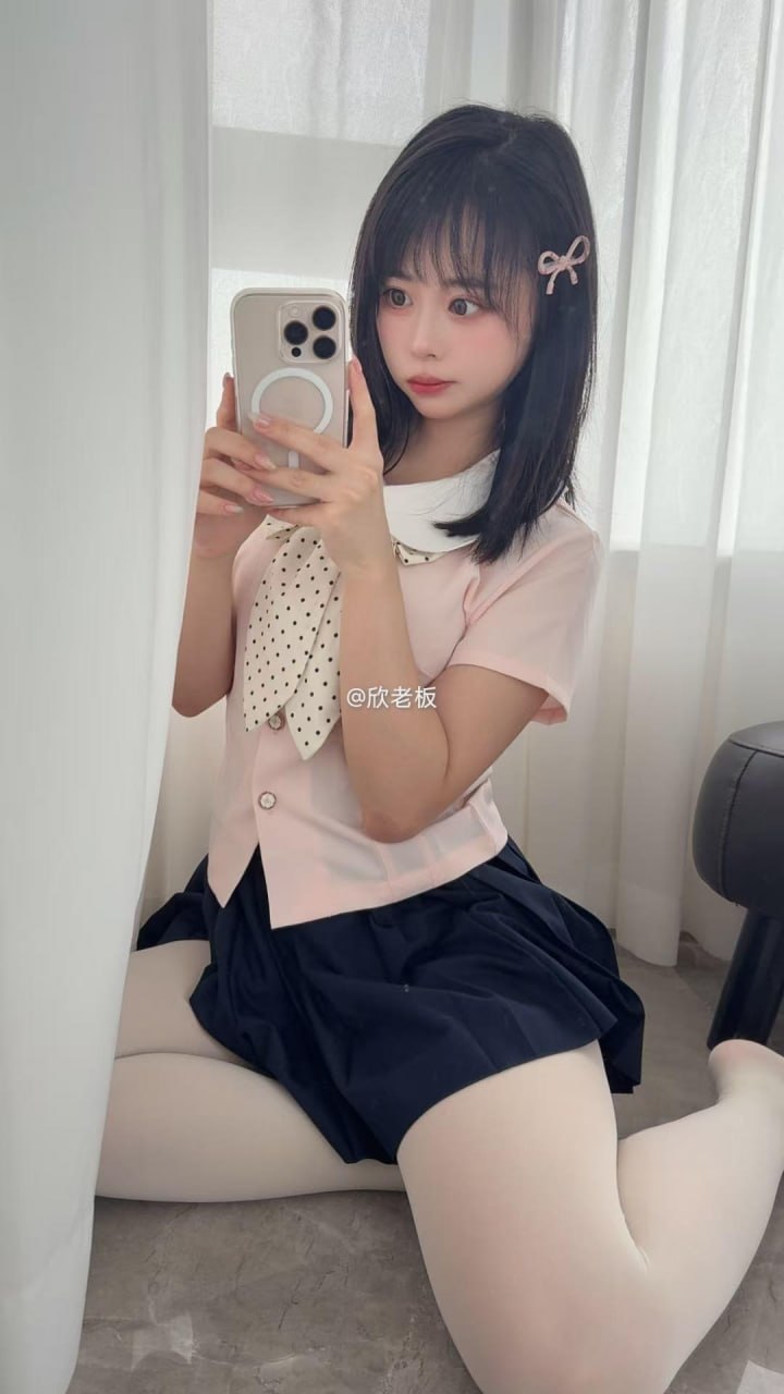 欣老板戴粉色蝴蝶结发夹,穿粉色短袖和深色褶裙在窗帘旁坐姿自拍 欣老板戴粉色蝴蝶结发夹,穿粉色短袖和深色褶裙在窗帘旁坐姿自拍