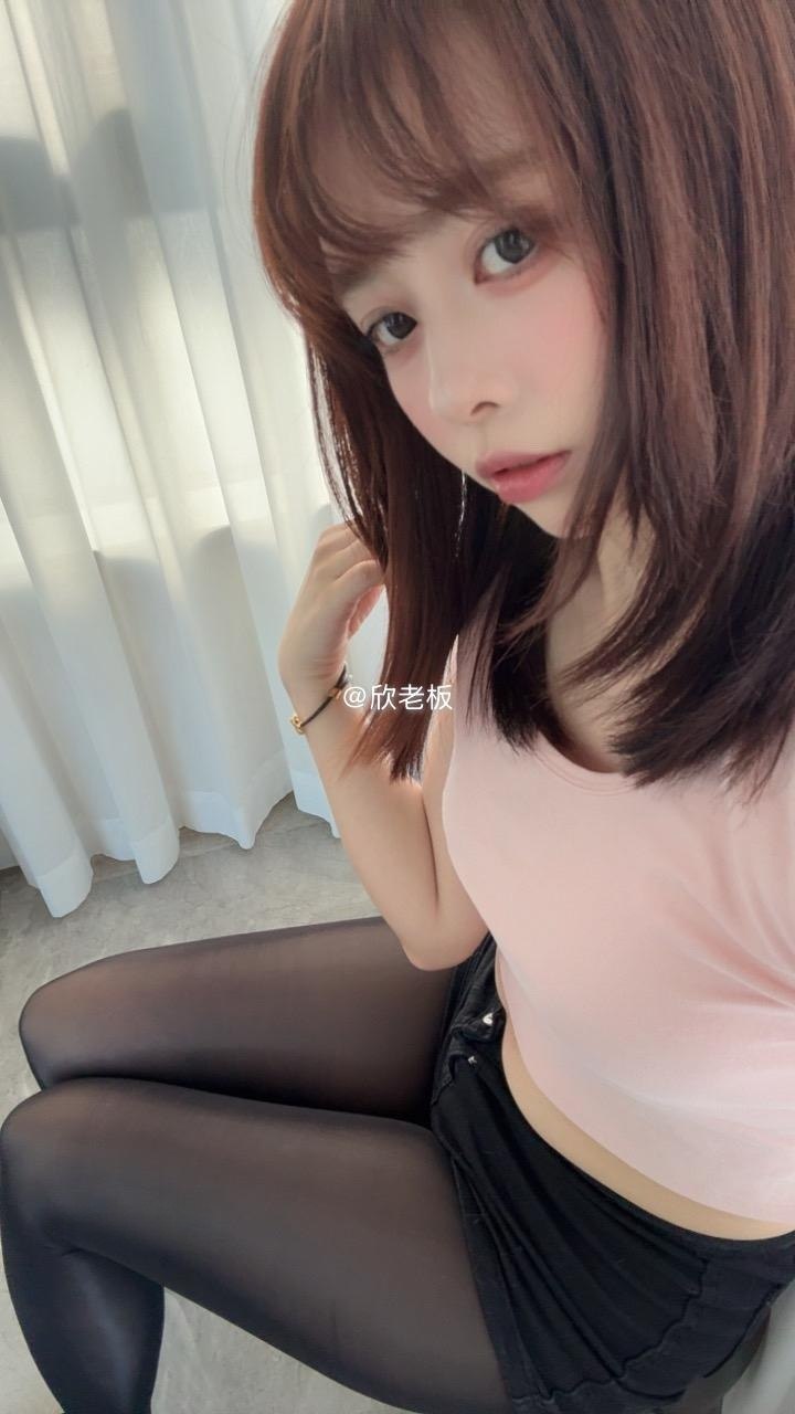 欣老板穿粉色上衣坐在窗旁,一手轻触棕色发束 欣老板穿粉色上衣坐在窗旁,一手轻触棕色发束
